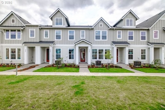 townhome / multi-family property featuring central AC unit, board and batten siding, and a front yard