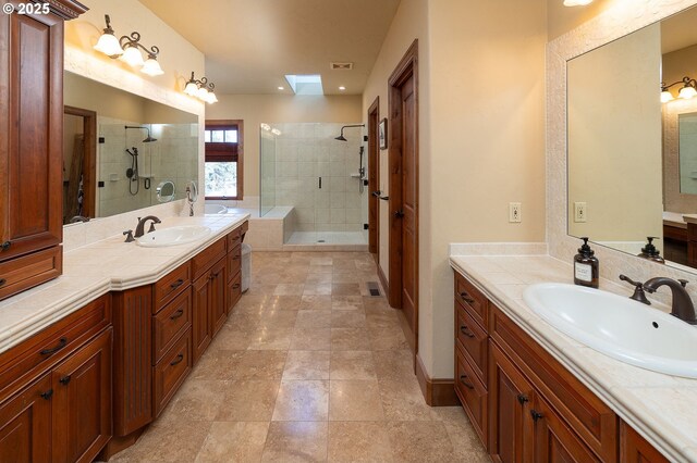 bathroom with a stall shower, two vanities, and a sink