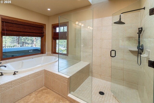 bathroom featuring a stall shower and a bath