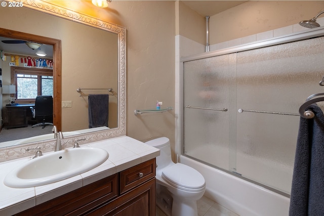 bathroom with shower / bath combination with glass door, vanity, toilet, and tile patterned floors