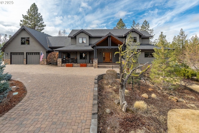 craftsman-style home with stone siding, a porch, and decorative driveway