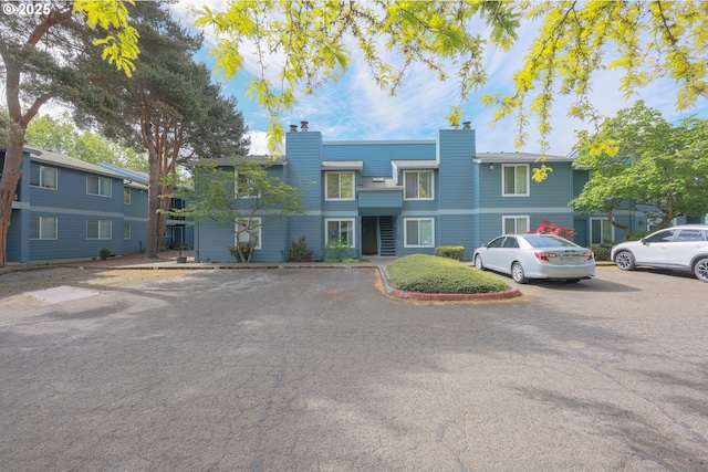2330 SE Brookwood Ave Unit 222, Hillsboro, OR 97123 - view of property featuring uncovered parking and a chimney