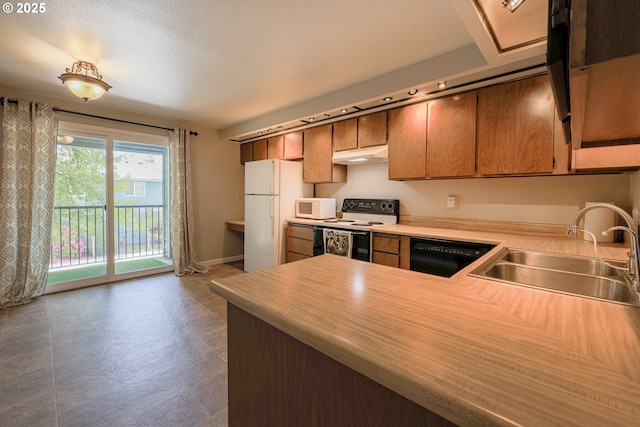 2330 SE Brookwood Ave Unit 222, Hillsboro, OR 97123 - kitchen with white appliances, a sink, under cabinet range hood, light countertops, and a peninsula