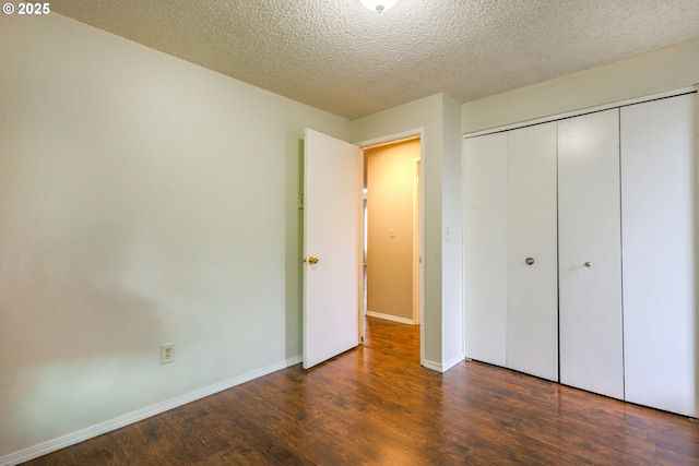2330 SE Brookwood Ave Unit 222, Hillsboro, OR 97123 - unfurnished bedroom with wood finished floors, a textured ceiling, a closet, and baseboards