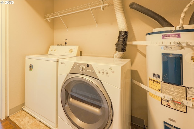 2330 SE Brookwood Ave Unit 222, Hillsboro, OR 97123 - laundry area featuring electric water heater, washing machine and dryer, and baseboards