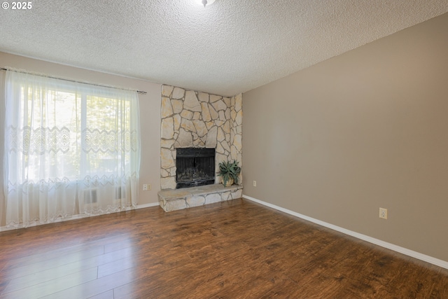 2330 SE Brookwood Ave Unit 222, Hillsboro, OR 97123 - unfurnished living room with wood finished floors, a textured ceiling, a fireplace, and baseboards