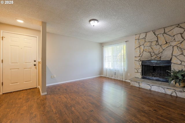 2330 SE Brookwood Ave Unit 222, Hillsboro, OR 97123 - unfurnished living room with wood finished floors, a stone fireplace, baseboards, and a textured ceiling