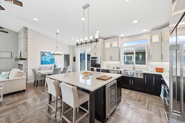 3220 Natalie Way, Bandon, OR 97411 - kitchen featuring a sink, beverage cooler, a breakfast bar, dark cabinets, and a chandelier