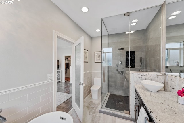 full bathroom with recessed lighting, a shower stall, tile walls, and vanity