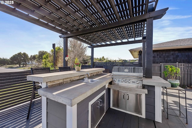 view of patio featuring outdoor dry bar, grilling area, an outdoor kitchen, a sink, and a pergola