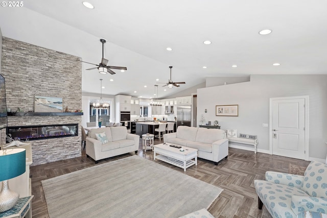 3220 Natalie Way, Bandon, OR 97411 - living room featuring a ceiling fan, lofted ceiling, a stone fireplace, a chandelier, and baseboards