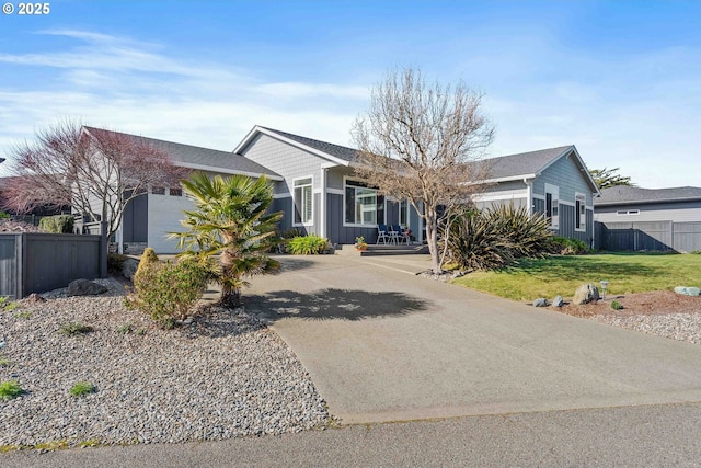 ranch-style house with concrete driveway, board and batten siding, fence, a garage, and a front lawn