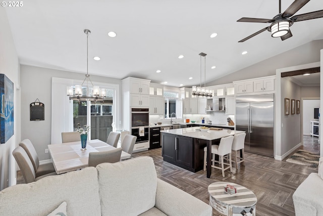 living area featuring lofted ceiling, baseboards, and recessed lighting