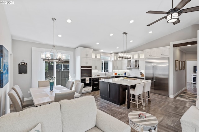 3220 Natalie Way, Bandon, OR 97411 - living room featuring a chandelier, baseboards, recessed lighting, a ceiling fan, and lofted ceiling