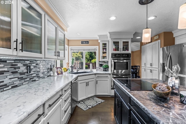 3644 Fall Creek Ct, Keizer, OR 97303 - kitchen featuring a sink, appliances with stainless steel finishes, backsplash, decorative light fixtures, and a textured ceiling