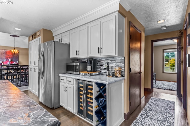 3644 Fall Creek Ct, Keizer, OR 97303 - kitchen with appliances with stainless steel finishes, beverage cooler, a textured ceiling, tasteful backsplash, and dark wood-style flooring