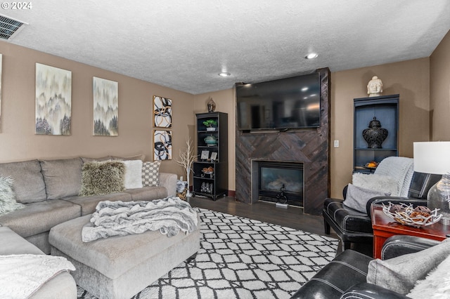 3644 Fall Creek Ct, Keizer, OR 97303 - living room featuring wood finished floors, a high end fireplace, a textured ceiling, and recessed lighting