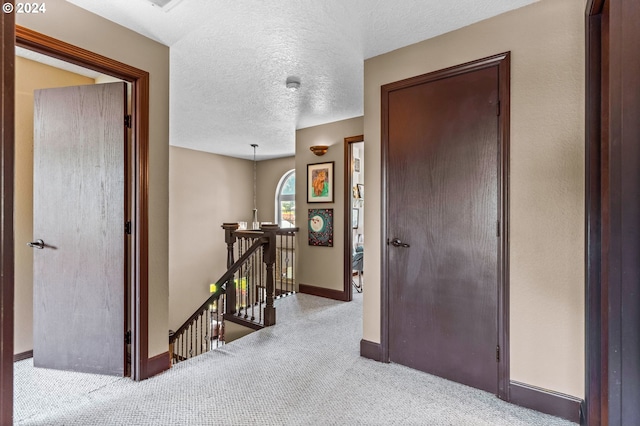 3644 Fall Creek Ct, Keizer, OR 97303 - hallway featuring an upstairs landing, carpet flooring, baseboards, and a textured ceiling