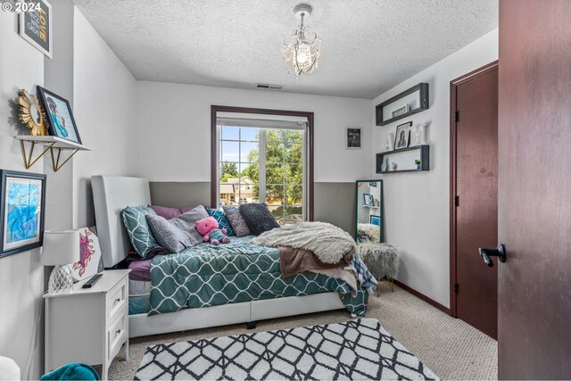 3644 Fall Creek Ct, Keizer, OR 97303 - bedroom with carpet flooring, a textured ceiling, a chandelier, and baseboards