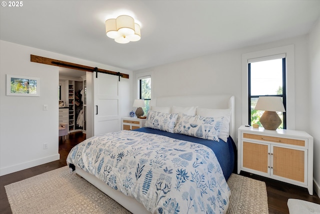 11700 S Makin Ln, Canby, OR 97013 - bedroom featuring a barn door, a walk in closet, dark wood-style flooring, and baseboards