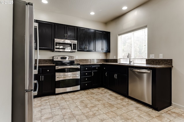 3980 Century Dr, Eugene, OR 97402 - kitchen with appliances with stainless steel finishes, dark cabinets, recessed lighting, and dark stone counters