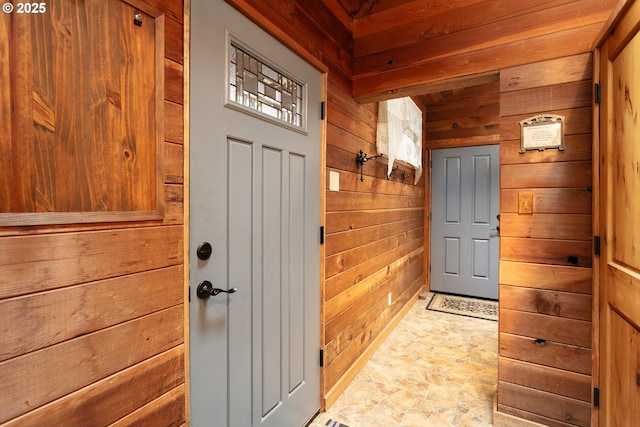 doorway to outside with wooden walls