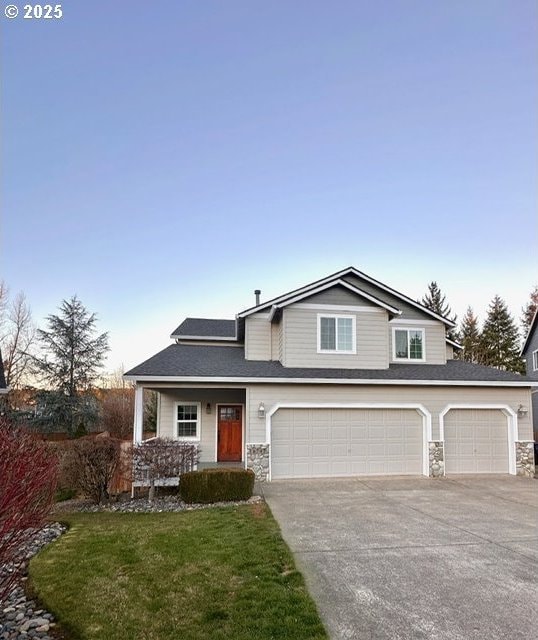 front facade with a garage, a front yard, and a porch