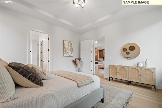 bedroom featuring light wood finished floors and baseboards