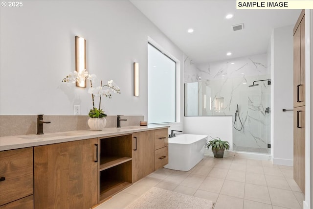 bathroom with a marble finish shower, double vanity, a freestanding bath, tile patterned floors, and recessed lighting