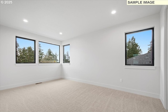 carpeted empty room featuring recessed lighting and baseboards