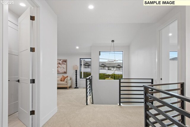 hallway featuring an upstairs landing, carpet, baseboards, and recessed lighting