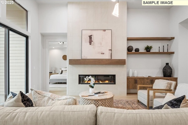 living area with a tile fireplace and wood finished floors