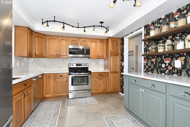 kitchen with appliances with stainless steel finishes, decorative backsplash, and light tile patterned floors