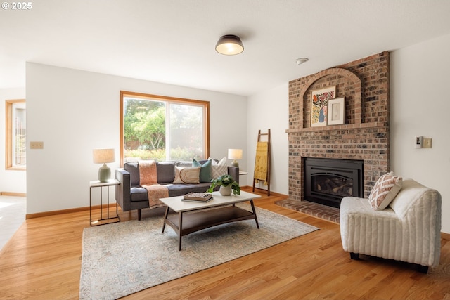8156 SW 159th Pl, Beaverton, OR 97007 - living room with wood finished floors, a brick fireplace, and baseboards
