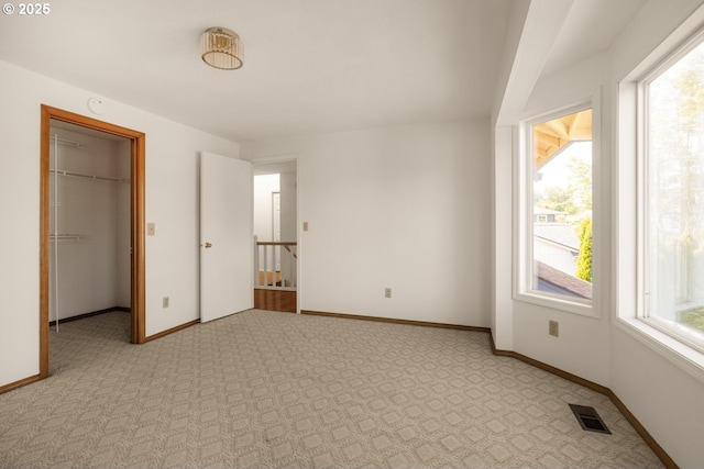 8156 SW 159th Pl, Beaverton, OR 97007 - unfurnished bedroom featuring multiple windows, a walk in closet, and light carpet