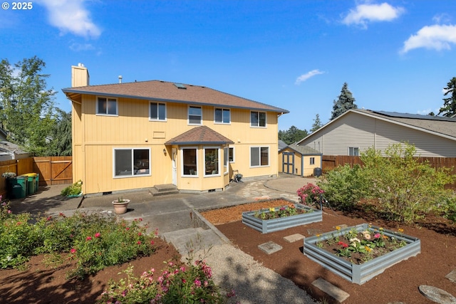 8156 SW 159th Pl, Beaverton, OR 97007 - rear view of property featuring a vegetable garden, a chimney, a patio area, a fenced backyard, and roof with shingles