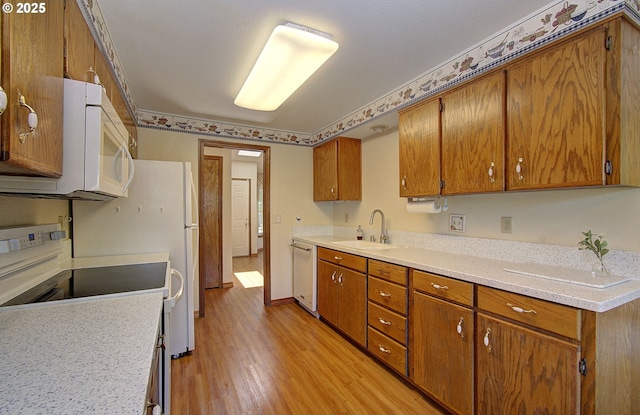 15798 SE 15th St, Vancouver, WA 98683 - kitchen featuring a sink, white microwave, brown cabinets, dishwasher, and light wood-type flooring