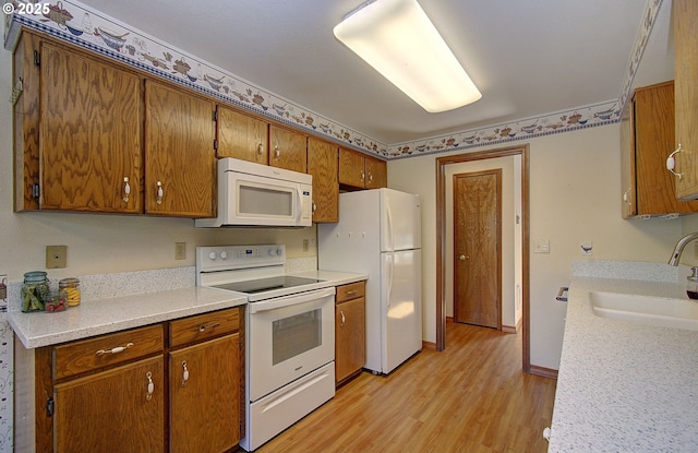 15798 SE 15th St, Vancouver, WA 98683 - kitchen featuring white appliances, a sink, light wood finished floors, and brown cabinetry