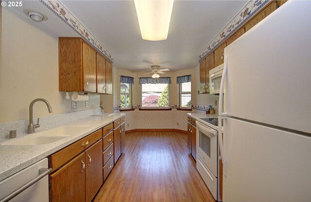 15798 SE 15th St, Vancouver, WA 98683 - kitchen featuring white appliances, a sink, light countertops, light wood-type flooring, and brown cabinetry