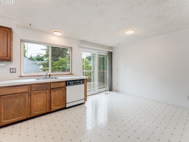 20621 SW Martinazzi Ave, Tualatin, OR 97062 - kitchen featuring dishwasher, a sink, light countertops, brown cabinets, and a textured ceiling