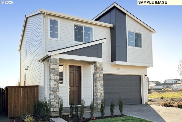 contemporary house with stone siding, an attached garage, concrete driveway, and fence