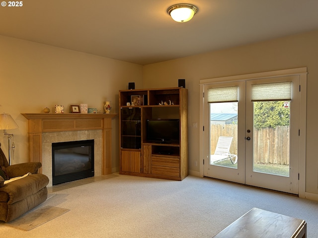 living room with light colored carpet, a fireplace, and french doors