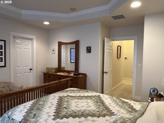 bedroom with ornamental molding and a raised ceiling