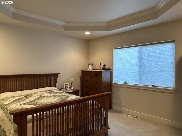 bedroom featuring crown molding, light colored carpet, and a tray ceiling