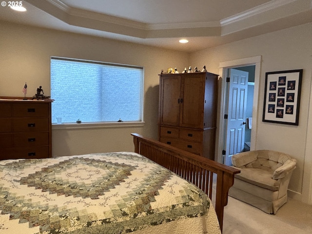 carpeted bedroom featuring ornamental molding and a tray ceiling