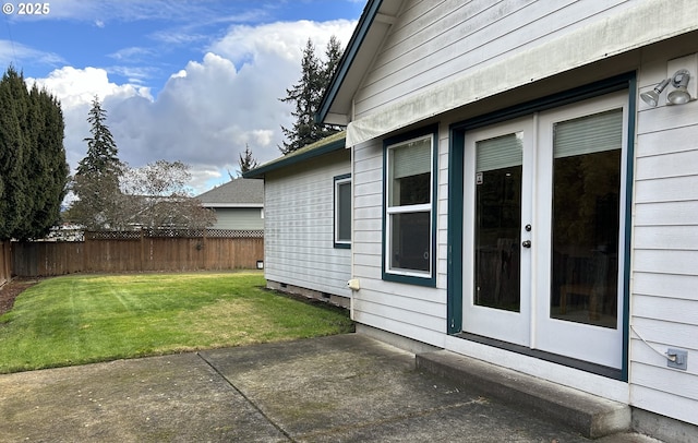 view of side of home featuring a yard, a patio area, and french doors