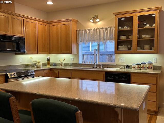 kitchen with sink, a breakfast bar area, and black appliances