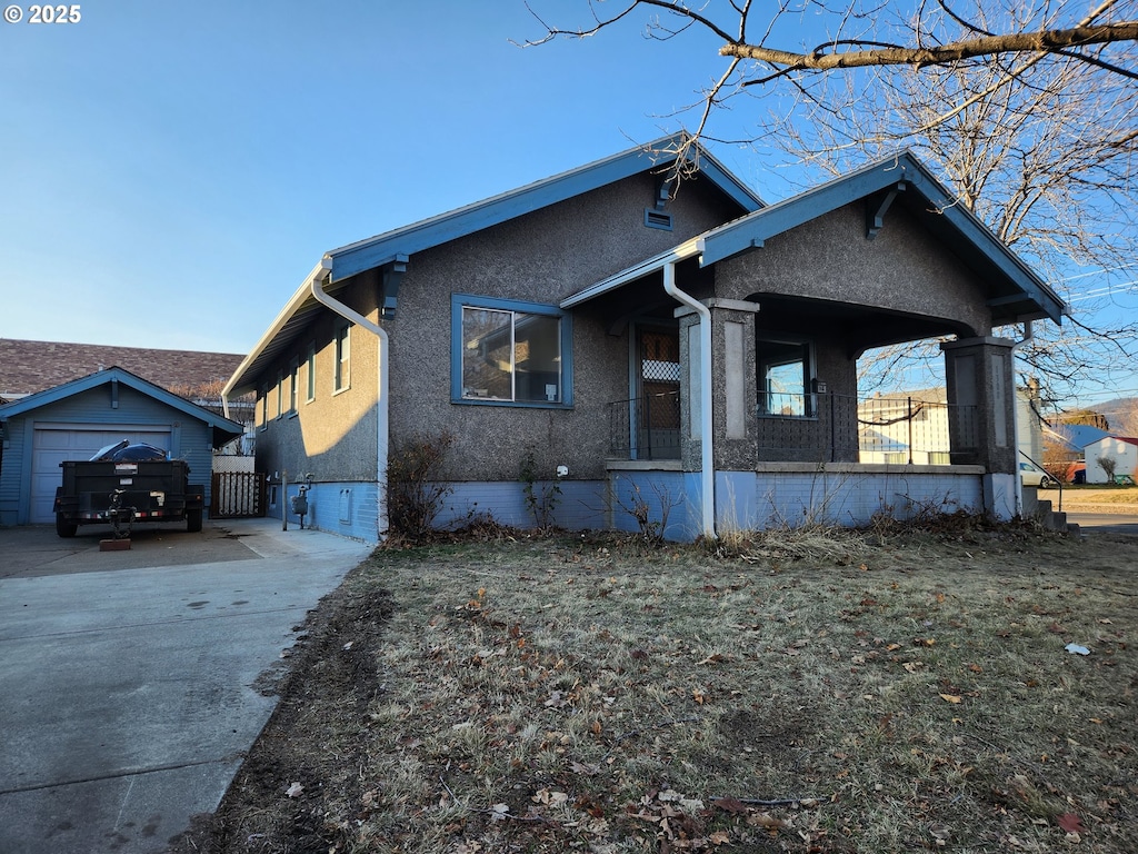 view of side of property featuring a garage and covered porch