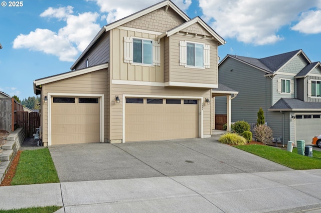 view of front of home featuring an attached garage, board and batten siding, driveway, and fence