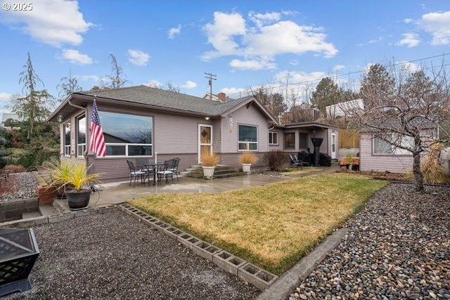 rear view of property with a yard and a patio